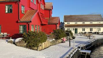 Ein rotes Gebäude mit einem Ziegeldach, einer Anlegestelle mit Reifen und einem wolkenlosen, blauen Himmel.