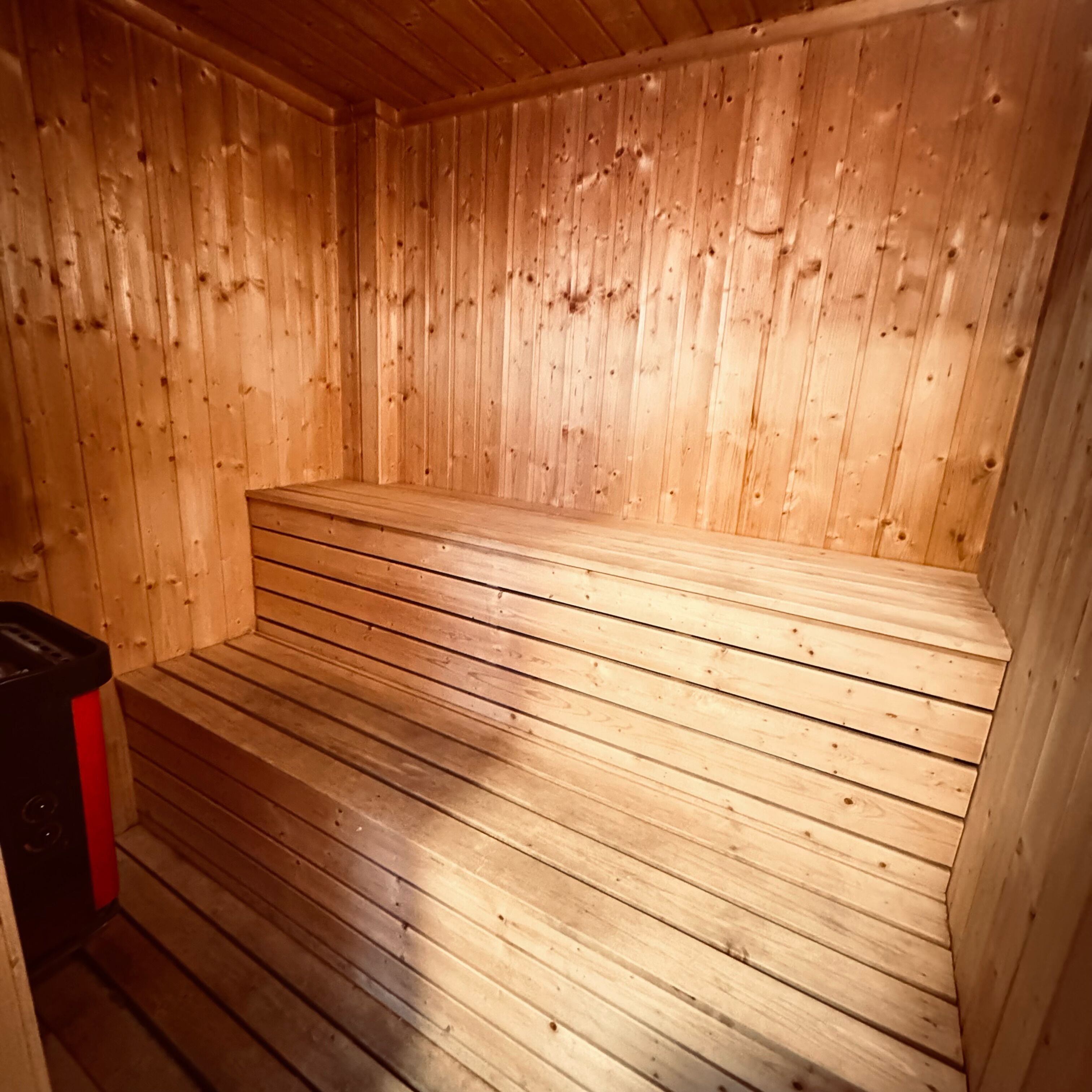 A sauna with wooden walls and a bench.