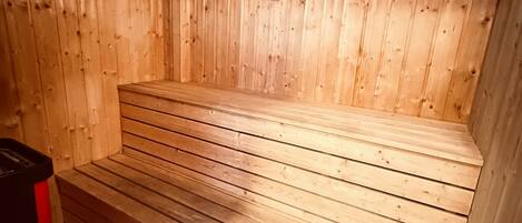 A sauna with wooden walls and a bench.