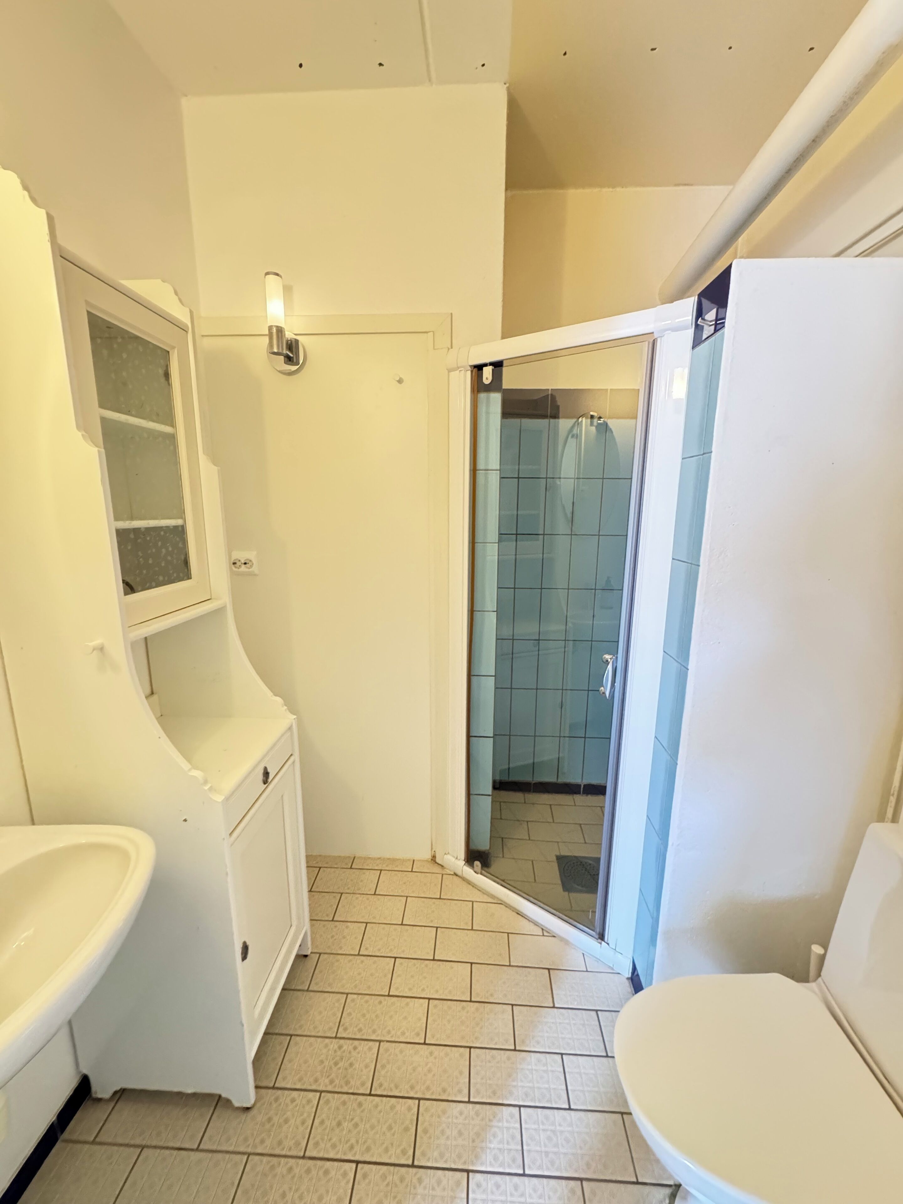 Ein Badezimmer mit Toilette, Waschbecken und Duschbereich.