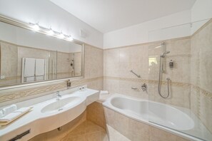 Habitación doble clásica | Baño | Tina con regadera, toallas, jabón, papel de baño 