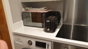 Uma cozinha com micro-ondas, torradeira e fogão de aço inoxidável.