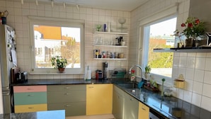 Une cuisine avec une fenêtre, un plancher en bois et un lave-vaisselle.