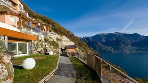 A pathway leading to a hillside property with a view of a lake and mountains. - EnjoyIseoLake - Colosseum - Parzanica (Parzanica)
