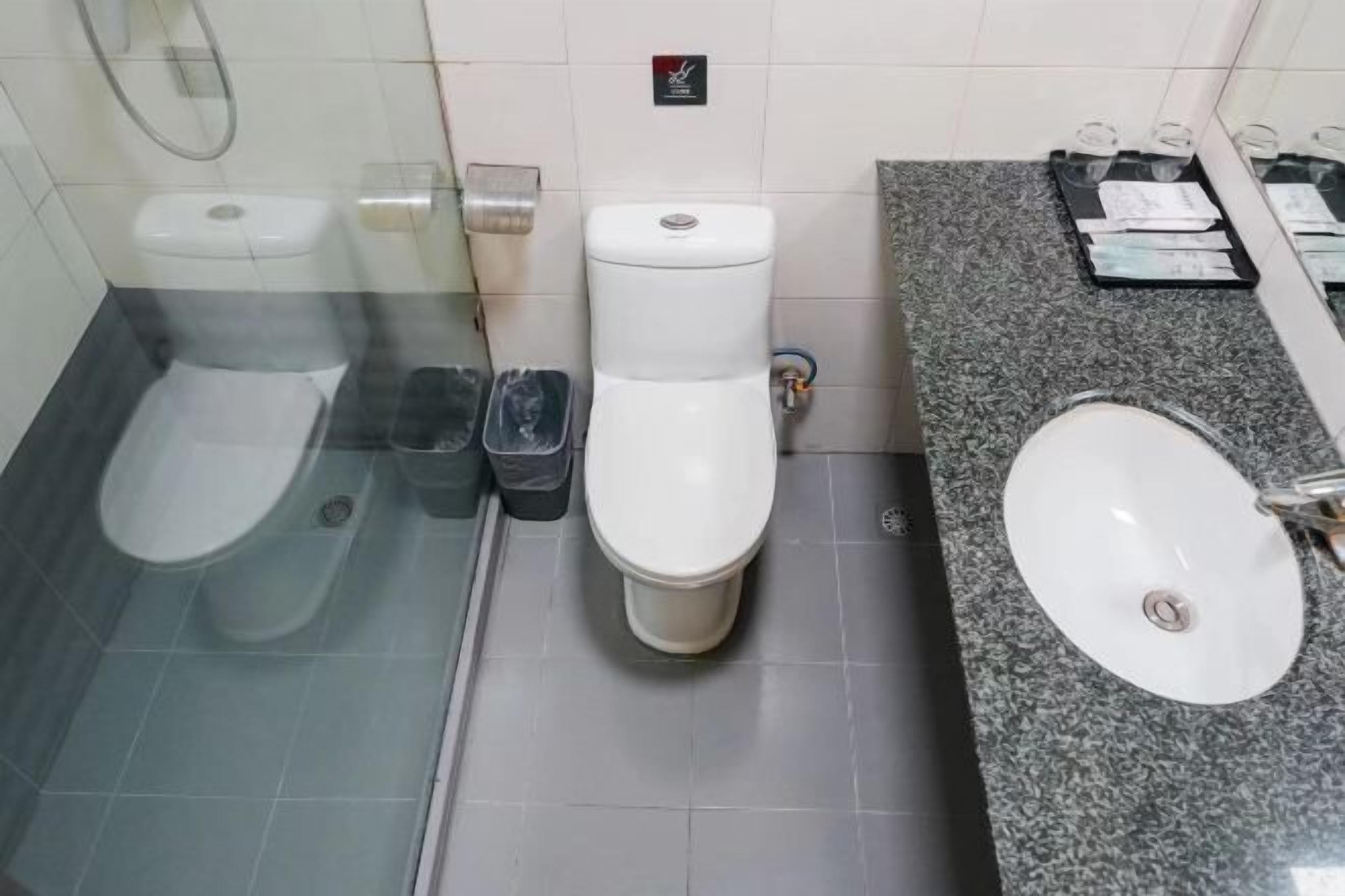 Un baño con inodoro, bidé y lavamanos.