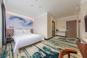 Una camera d'albergo con un letto, una scrivania, una sedia e un grande quadro astratto appeso alla parete.