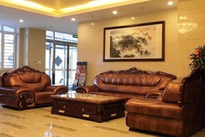 A lobby with leather sofas, a coffee table, and a framed artwork on the wall. - Beijing Ruya Business Hotel (Wangjing Subway Station) (Beijing)