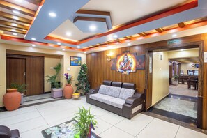 A lobby with a sofa, potted plants, and a reception desk. - Hotel Airport Deepshree (Kathmandu)