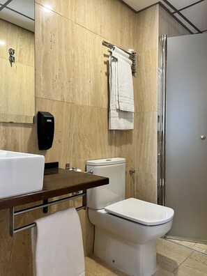 Klassieke eenpersoonskamer | Badkamer | Een douche, een haardroger, handdoeken, zeep