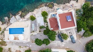 An aerial view of a coastal property with a swimming pool, a tennis court, and a red-roofed building. - Luxury Villa Solis (Karlobag)