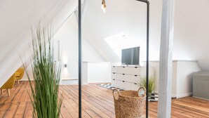A modern loft with a wooden floor, a hanging plant, a swing, and a view of the sky through a skylight. - fewo1846 - flensBURG / centrally located, elegant maisonette apartment on the 4t (Flensburg)