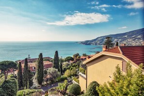 A coastal town with Mediterranean architecture, including terracotta roofs and stucco walls, overlooking the sea.