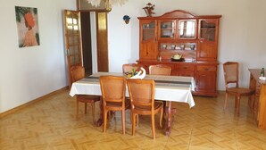 Un coin repas avec une table en bois, des chaises et un buffet.