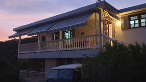 Un immeuble de deux étages doté d’un balcon et d’un porche abrité.