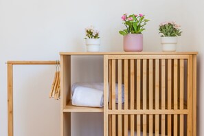 A wooden shelf with folded towels and three potted plants. - Casa Azul - Jardim do Morro (Vila Nova de Gaia)