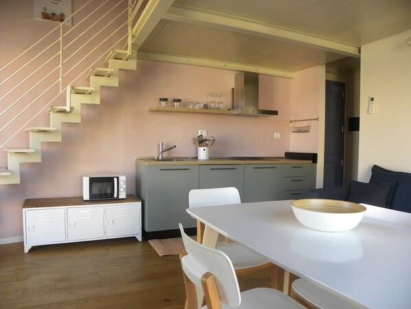 Une cuisine moderne équipée d’un four à micro-ondes, d’un évier et d’un escalier en bois.