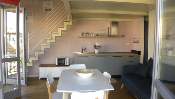 A compact living space with a kitchen, dining area, and a staircase. - Only 20 min from Olbia: charming 2-bedroom apartment in San Pantaleo with wifi (San Pantaleo)