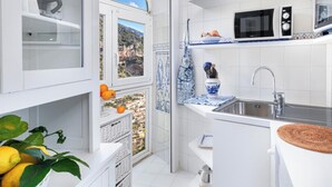 A modern kitchen with white cabinetry, a built-in microwave, and a large window offering a scenic view.