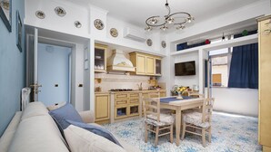 Ein gemütlicher Wohnraum mit Küchenzeile, Essbereich und Sofa.