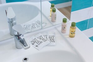 Ein Badezimmer mit Waschbecken, Spiegel und Pflegeprodukten.