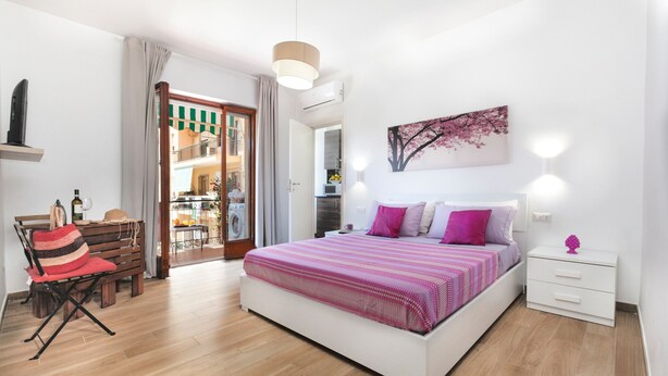 Un dormitorio con cama, mesita de noche y una silla.