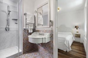 Ein Badezimmer mit Dusche, Waschbecken und Spiegel.