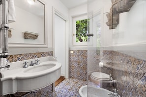 Ein Badezimmer mit Waschbecken, Toilette und Duschbereich.