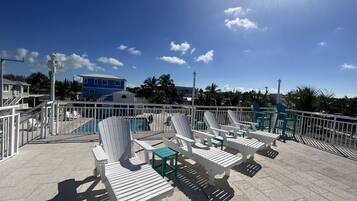 Relax on the rooftop terrace with a clear view of the pool, surrounded by lounge chairs and tables.