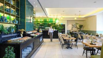 A restaurant with a buffet, a bar, and a seating area with tables and chairs.