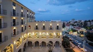 A multi-story hotel with balconies, a courtyard, and a view of the cityscape. - Hotel Botanica- Limited Edition By Fattal (Haifa)