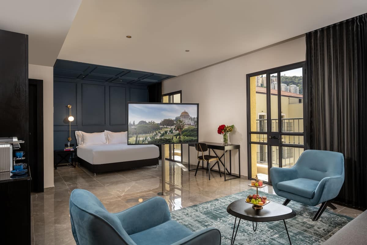 Una habitación de hotel moderna con una cama, un escritorio, un televisor y dos sillas.