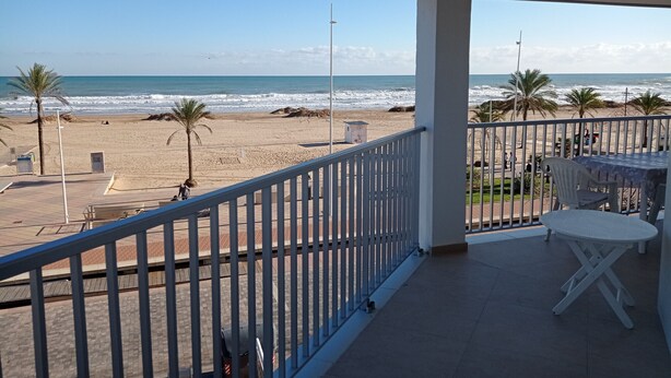 Un balcón con vista a la playa y al océano.