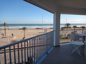 A balcony with a view of the beach and ocean.