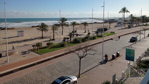 Una carretera costera con vista a la playa, palmeras y el letrero de un restaurante.