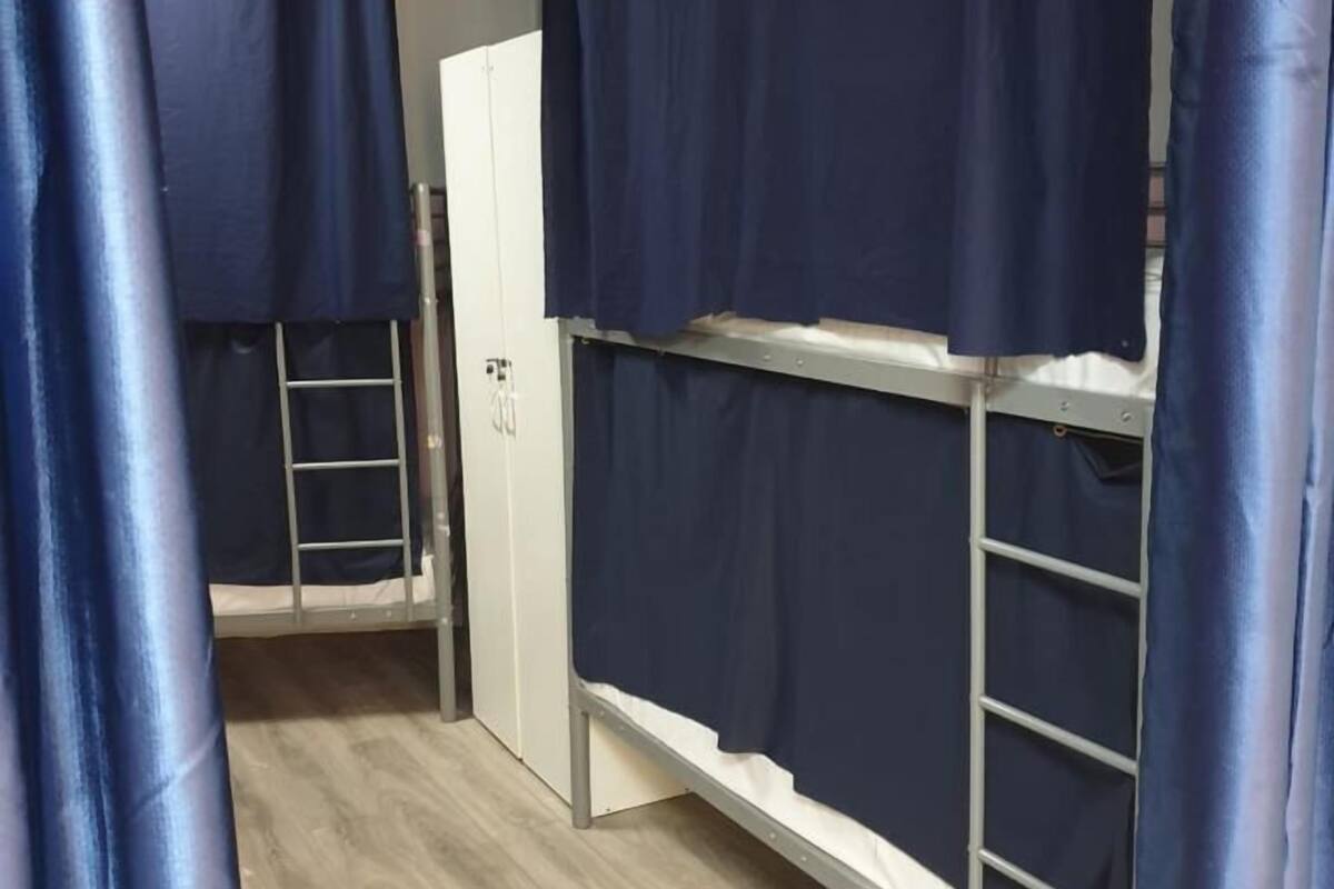 Ein Zimmer mit Etagenbetten, einem Kleiderschrank und einer Tür.