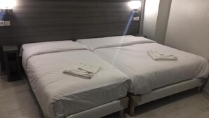 Un lit double avec une tête de lit en bois et deux tables de chevet.