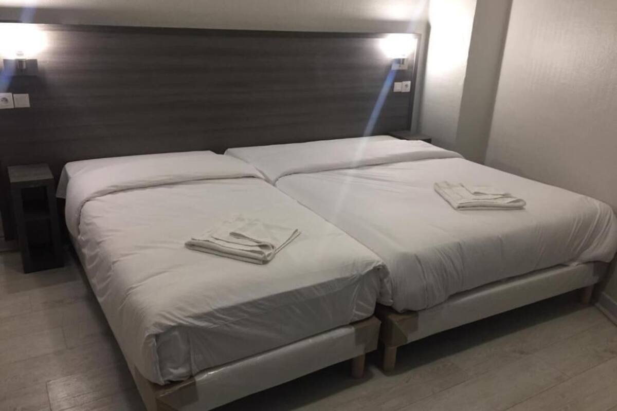 Ein Doppelbett mit Holz Kopfteil und zwei Nachttischen.