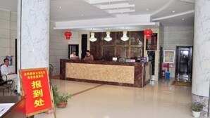 A hotel reception area with a marble reception desk, red lanterns, and a sign indicating a location. - Shengcheng Jiayuan Hotel (Leishan)