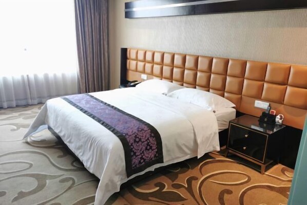 A hotel room with a large bed, a headboard, a nightstand, and a carpeted floor. - Park Lane Yiju Hotel (Jiangmen Taishan Pedestrian Street Pinghu Road) (Taishan)