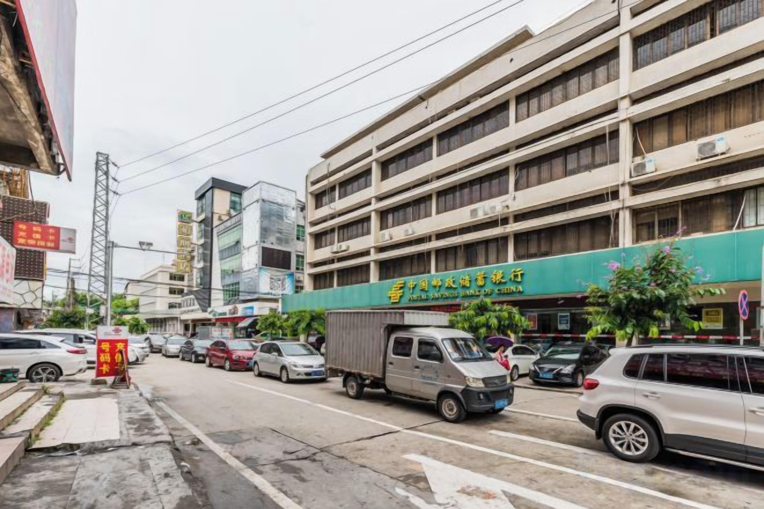 A multi-story parking garage with a green storefront on the ground floor.