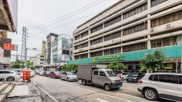 A multi-story parking garage with a green storefront on the ground floor.