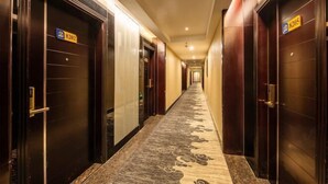 A hotel corridor with doors labeled 8202 and 8205, carpeted with a floral pattern, and a ceiling with recessed lighting. - Park Lane Yiju Hotel (Jiangmen Taishan Pedestrian Street Pinghu Road) (Taishan)