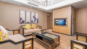Uma sala de estar moderna com sofá, mesa de centro e televisão fixada na parede.