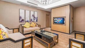 Uma sala de estar moderna com sofá, mesa de centro e televisão na parede.