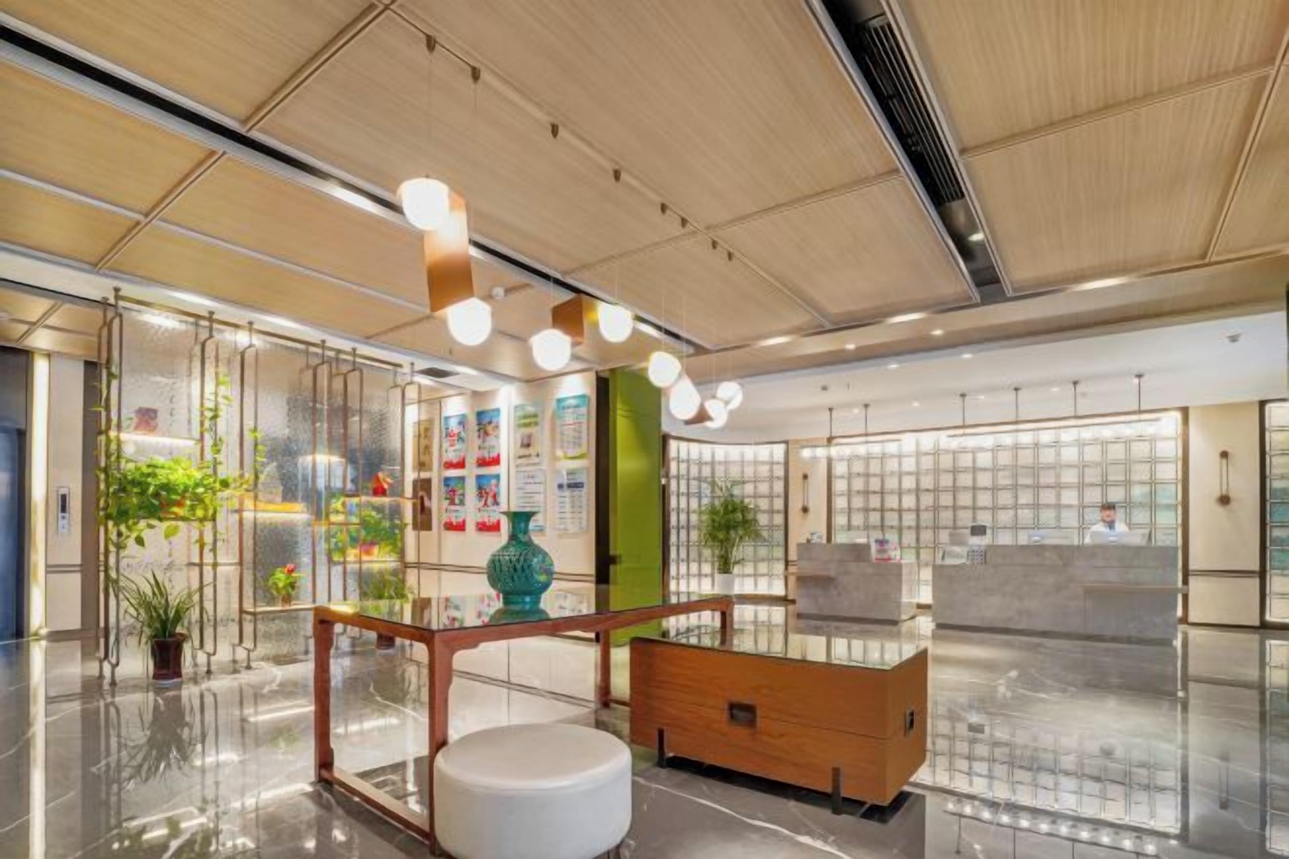 Un moderno vestíbulo de hotel con un mostrador de recepción de madera, un banco blanco y una partición de vidrio.