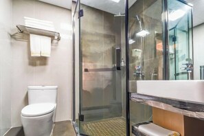 A modern bathroom with a glass-enclosed shower, a white toilet, and a sink with a marble countertop. - Yunlong Hotel (Zhuxi)