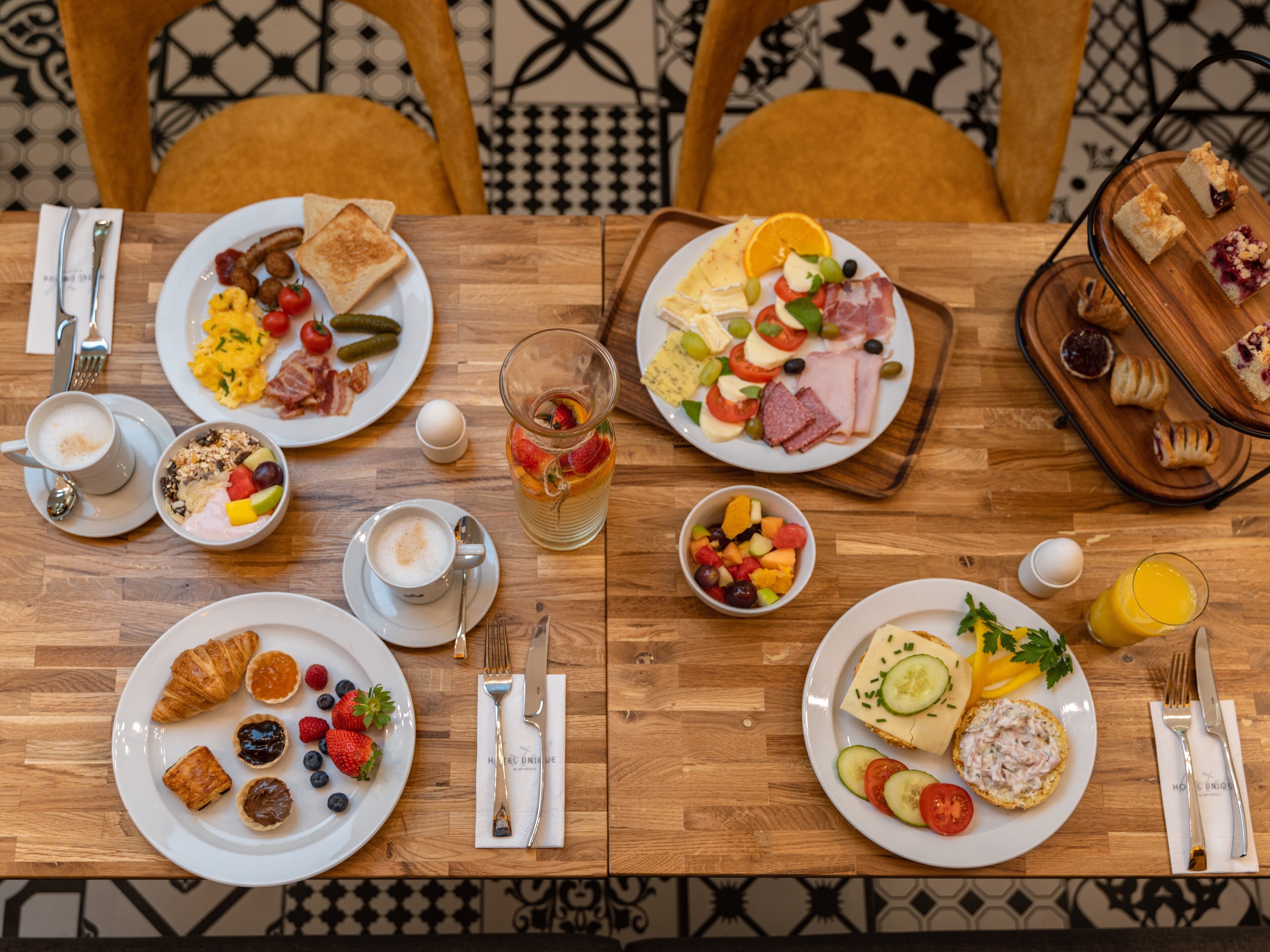A breakfast buffet with various dishes, including toast, eggs, fruits, and pastries.
