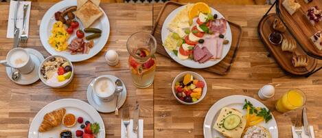 A breakfast buffet with various dishes, including toast, eggs, fruits, and pastries.