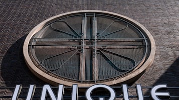 A circular window with a metal grille design, set in a brick wall.