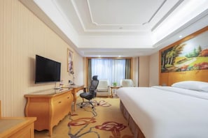 A hotel room with a bed, a desk with a chair, a television, and a painting on the wall. - Vienna Hotel (Xinhua South Store, Hankou North Road, Wuhan) (Wuhan)